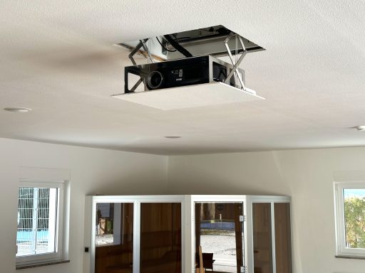 Deckenprojektor installiert in einem modernen Raum mit weißen Wänden.