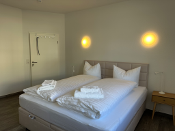 Schlafzimmer mit zwei Betten, weißen Kissen und Handtüchern, stilvolles Ambiente.