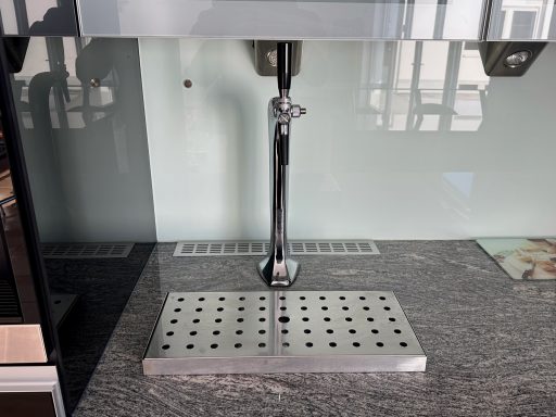 Moderne Edelstahl-Bierzapfstelle mit gepunkteter Abtropfschale.